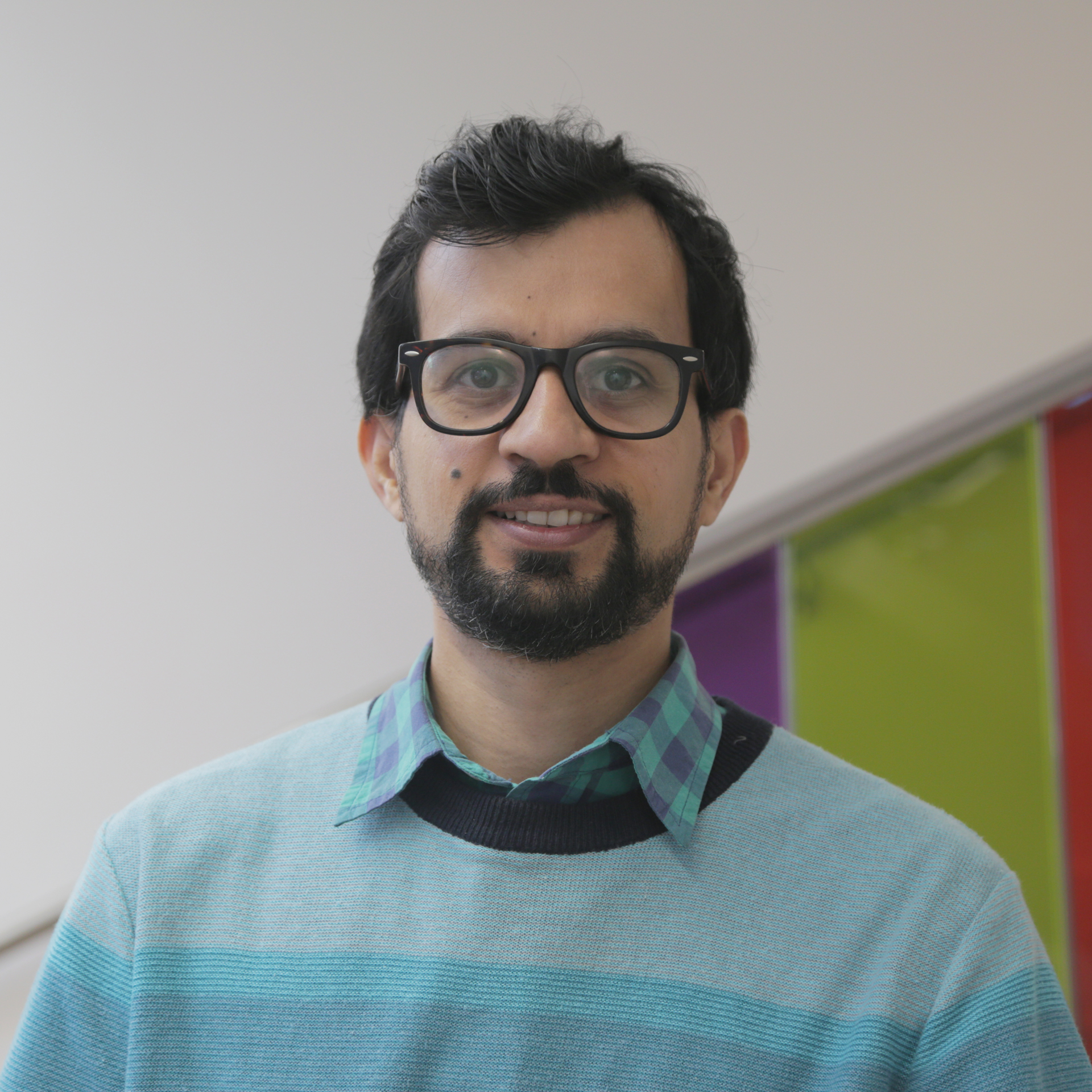 A man with glasses and a blue sweater